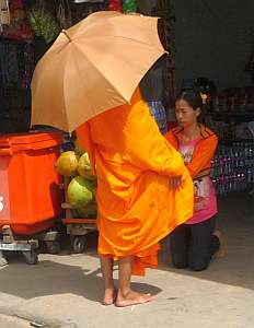 Woman giving alms to a monk