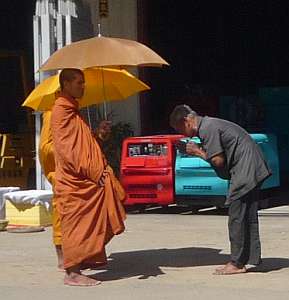 Man giving alms to a monk