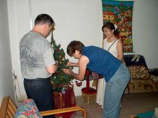 Kathy and John Tucker and a guest decorating a tree