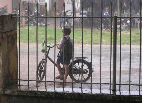 School boy waiting for the rain to stop