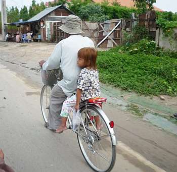 Little girl on back of a bicycle