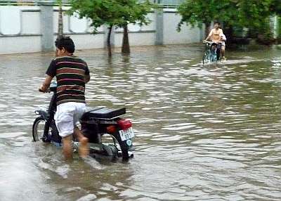 Pushing a flooded motorbike