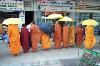 A line of monks begging on a street