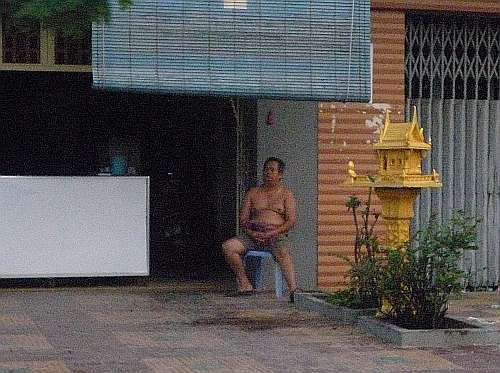 Man sitting in front of his house